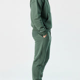 Side profile of the Herman men's green popper neck hoodie and joggers.