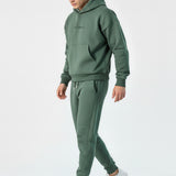 Side view of a model walking in the Herman men's green hoodie and joggers set.