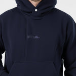 Close-up detail of the popper neck and tonal embroidered logo on the Herman navy hoodie.