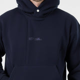 Close-up detail of the popper neck and tonal embroidered logo on the Herman navy hoodie.