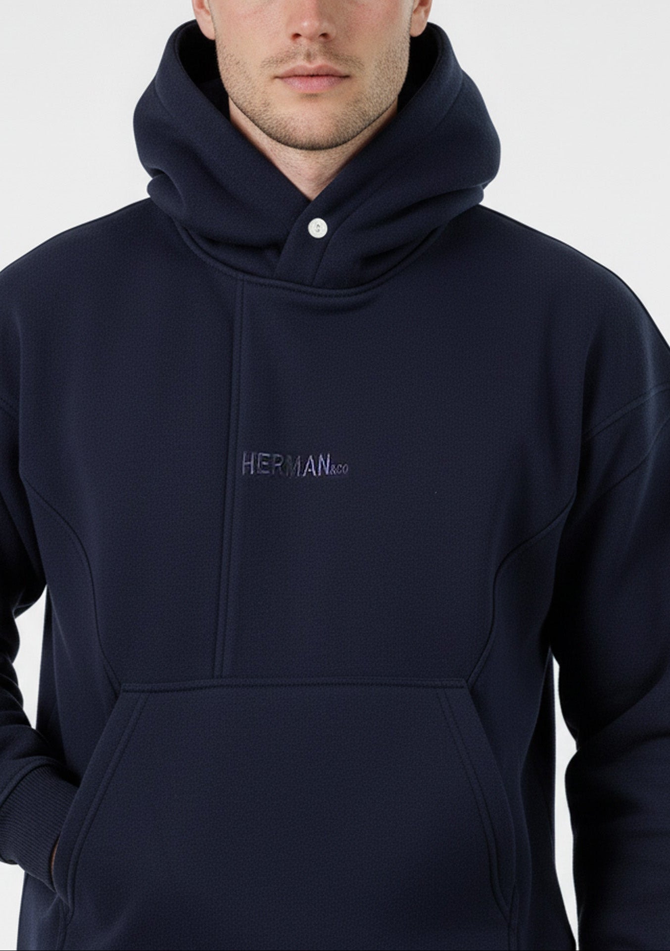 Close-up detail of the popper neck and tonal embroidered logo on the Herman navy hoodie.