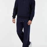 Angled front view of a model wearing the Herman men's navy popper neck hoodie and joggers set.