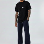 Model wearing the Herman men's navy wide-leg joggers styled with a black t-shirt.