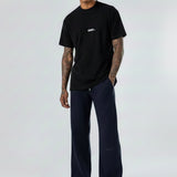 Model wearing the Herman men's navy wide-leg joggers styled with a black t-shirt.