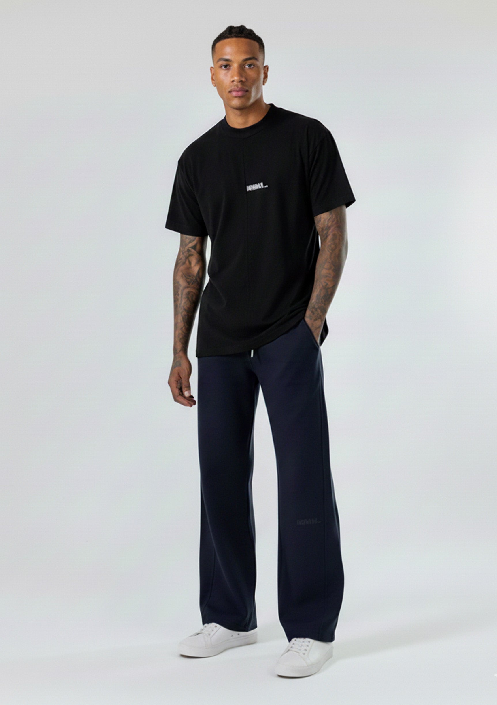 Model wearing the Herman men's navy wide-leg joggers styled with a black t-shirt.
