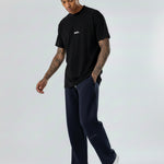 Side view of a model walking in the Herman men's navy wide-leg joggers.