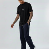 Side view of a model walking in the Herman men's navy wide-leg joggers.