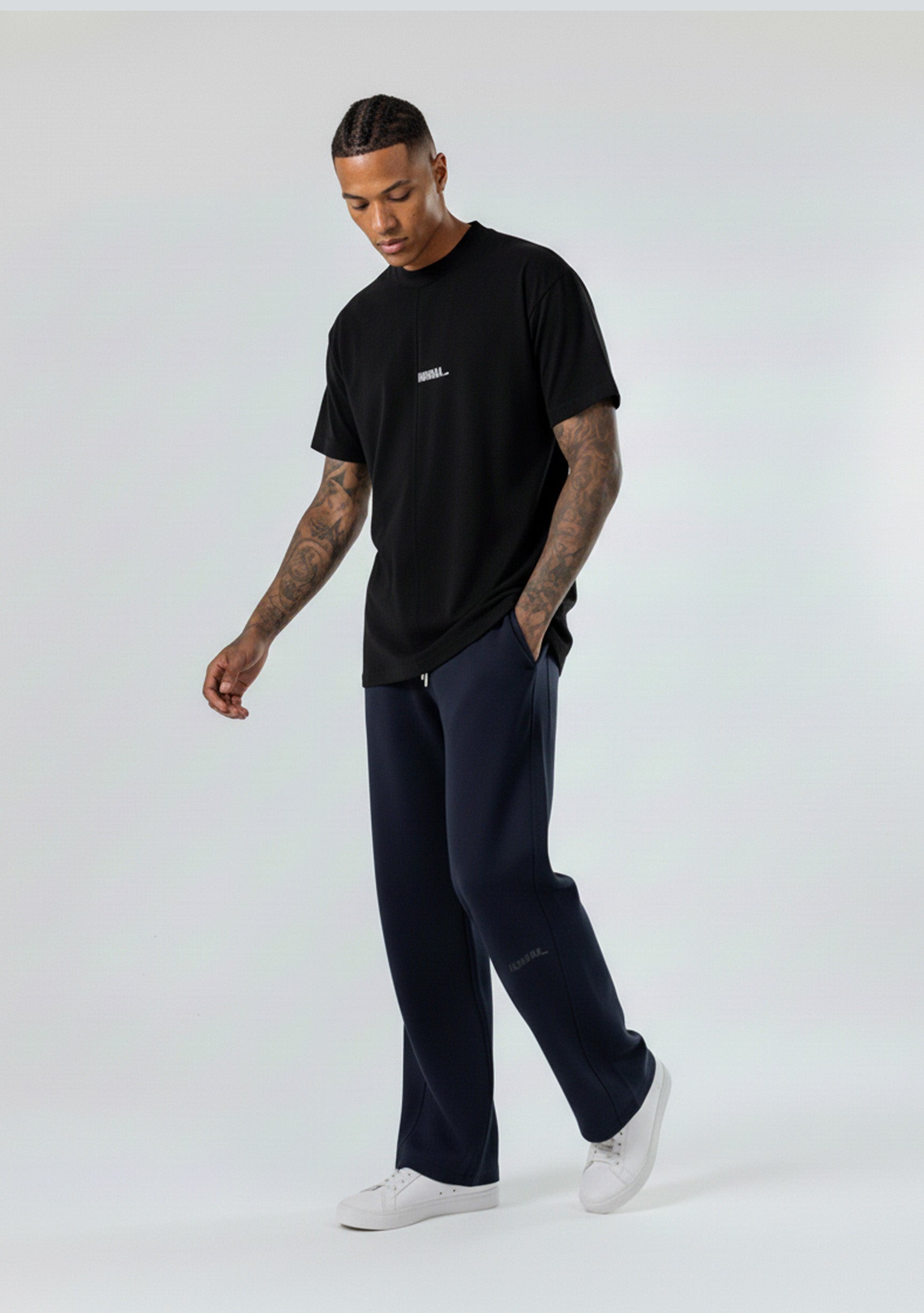 Side view of a model walking in the Herman men's navy wide-leg joggers.