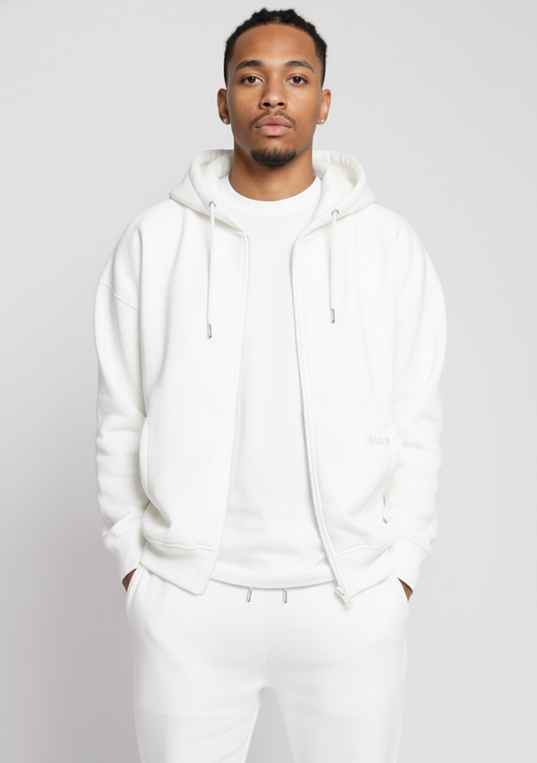 Model wearing the Herman men's white oversized zip hoodie with matching joggers