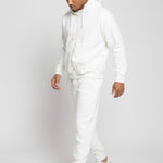Full length side view of a model walking in the Herman men's white zip hoodie and joggers