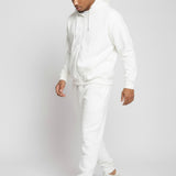 Full length side view of a model walking in the Herman men's white zip hoodie and joggers