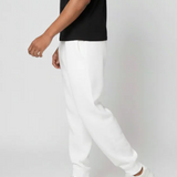 Side view of the Herman men's white joggers showing the tapered silhouette and cuffed ankle