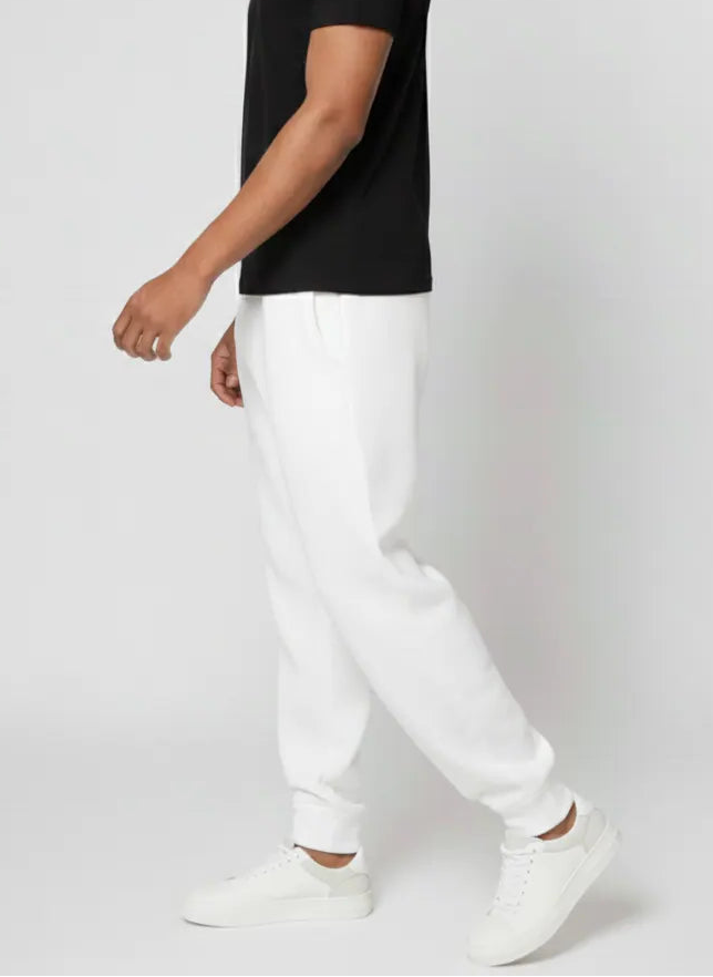 Side view of the Herman men's white joggers showing the tapered silhouette and cuffed ankle