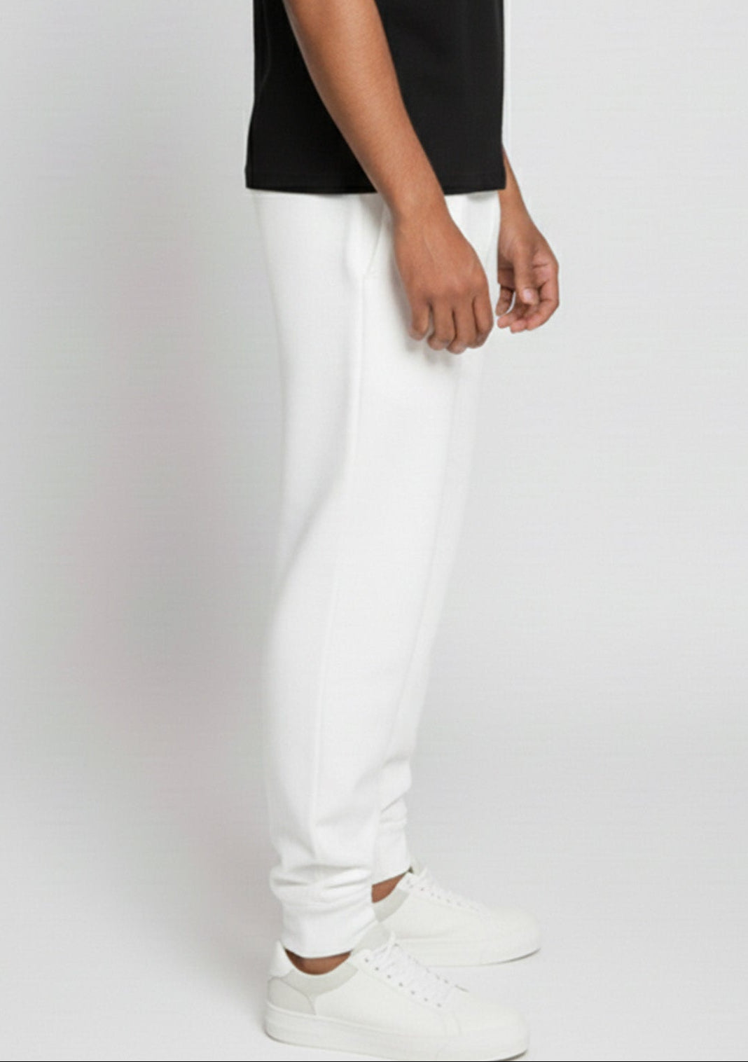 Full side profile of a model wearing the Herman men's white tapered joggers