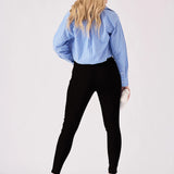 Rear view of a woman wearing slim-fitting black jeggings to show the high-waisted design and flattering fit.