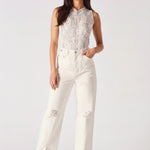 Front view of model wearing high-rise white wide-leg jeans with thigh distressing.