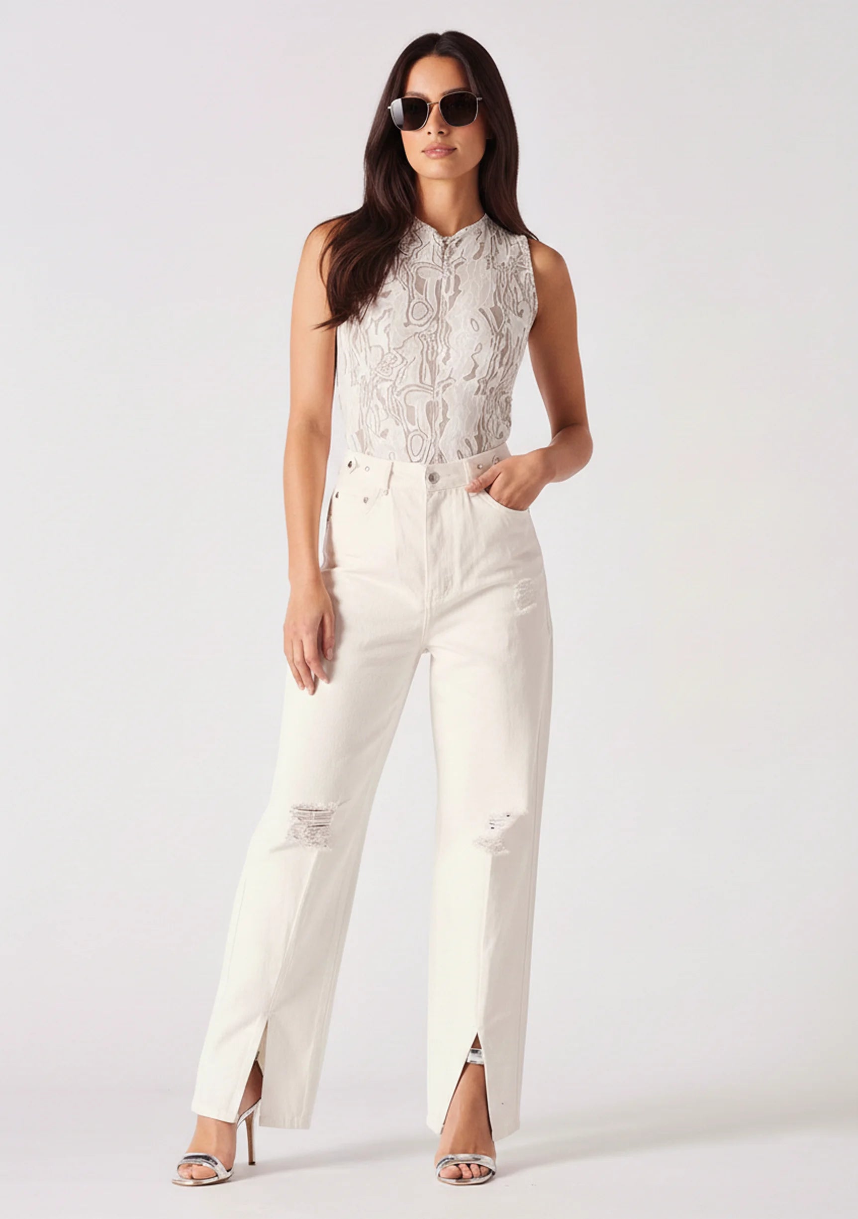 Front view of model wearing high-rise white wide-leg jeans with thigh distressing.