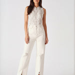 Full body studio shot of model standing in high-waist white jeans.