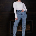 A model posing in the high-waisted acid wash skinny jeans
