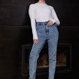 A model posing in the high-waisted acid wash skinny jeans