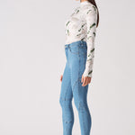 Side profile of a model showing the fit of the high-waisted blue skinny jeans.