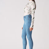 Side profile of a model showing the fit of the high-waisted blue skinny jeans.
