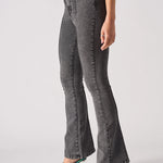 Angled side view showcasing the form-fitting silhouette of grey bootcut jeans