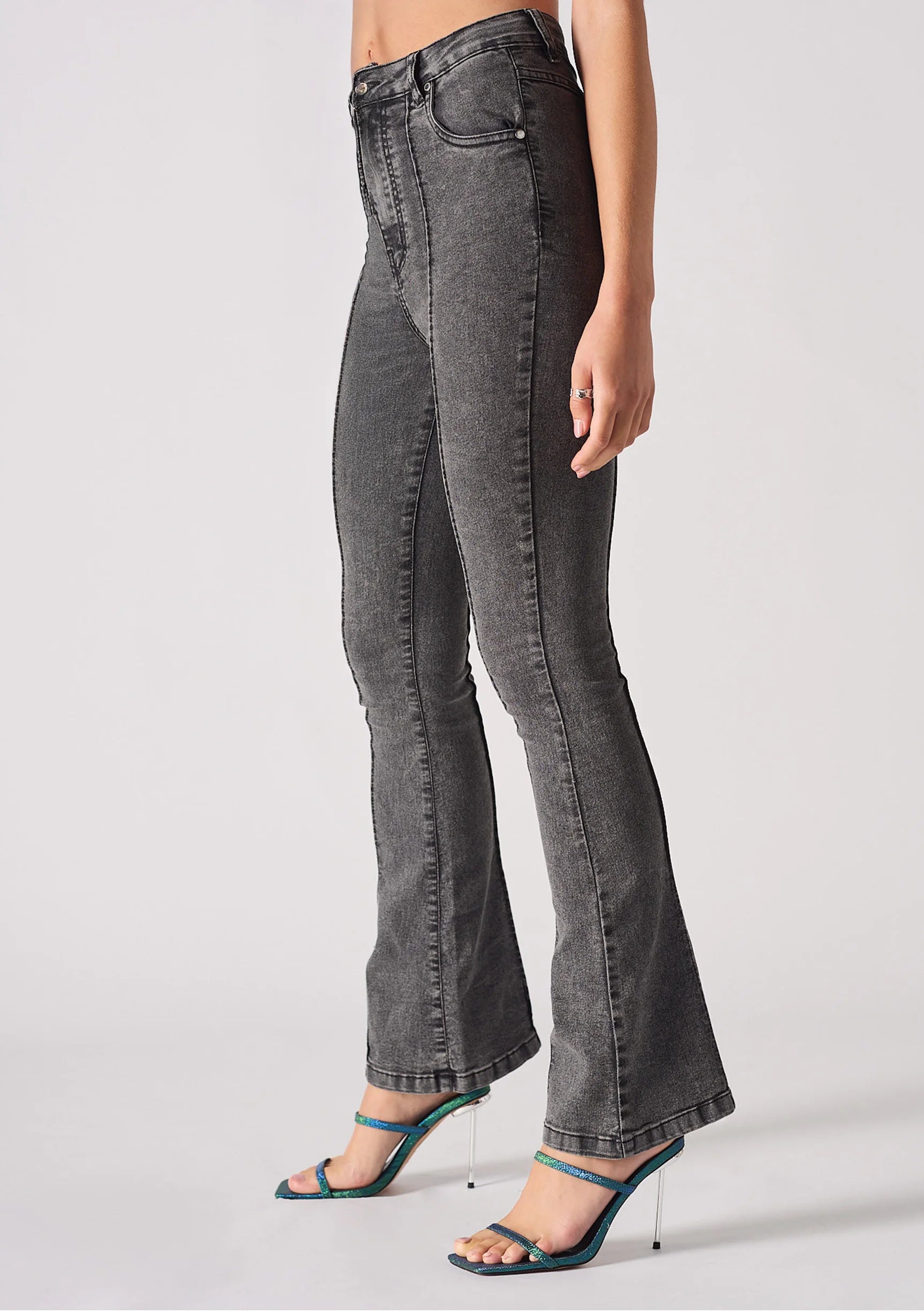 Angled side view showcasing the form-fitting silhouette of grey bootcut jeans