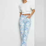 Model walking in high-waisted marble effect straight jeans, showing the drape of the split hem.