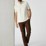Model leaning against wall wearing JMOJO men's dark brown slim fit chinos