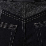 Close up of Herman and Co vegan leather branding patch and back patch pockets on black acid wash jeans