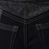 Close up of Herman and Co vegan leather branding patch and back patch pockets on black acid wash jeans