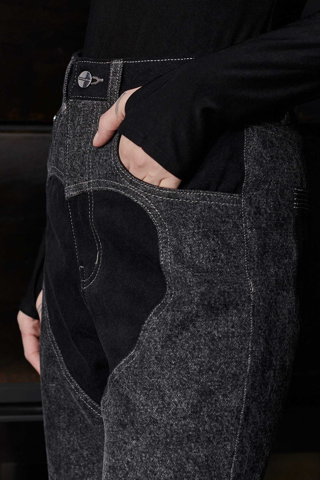 Close up of silver branded button hardware and heart cut out panel detail on Jmojo black wash jeans