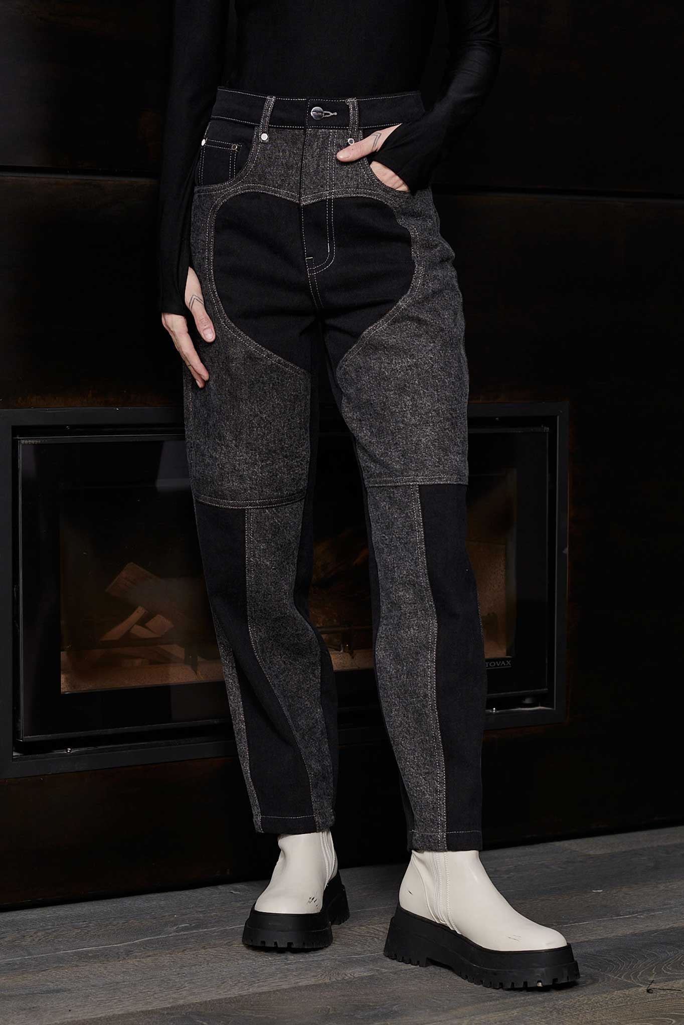 Close up front view of Jmojo black acid wash heart panel tapered jeans on model