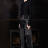 Side view of model wearing Jmojo black and acid wash tapered fit heart panel jeans