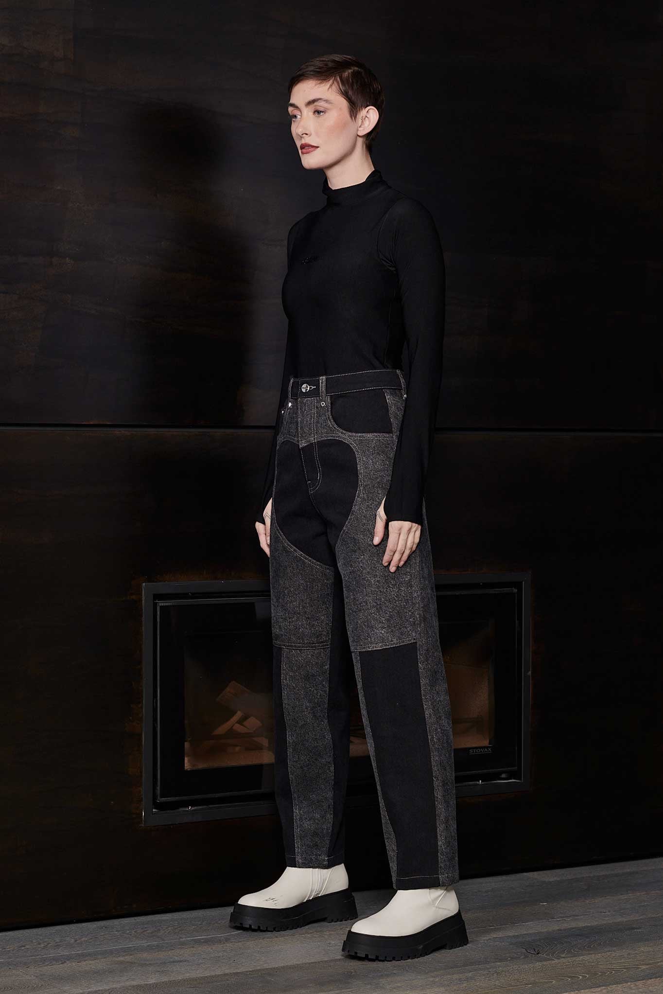 Side view of model wearing Jmojo black and acid wash tapered fit heart panel jeans