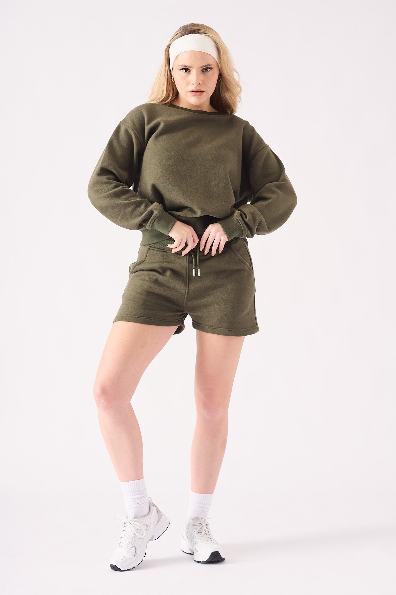 Close up front view of the soft fabric and waist of a khaki crew neck jumper