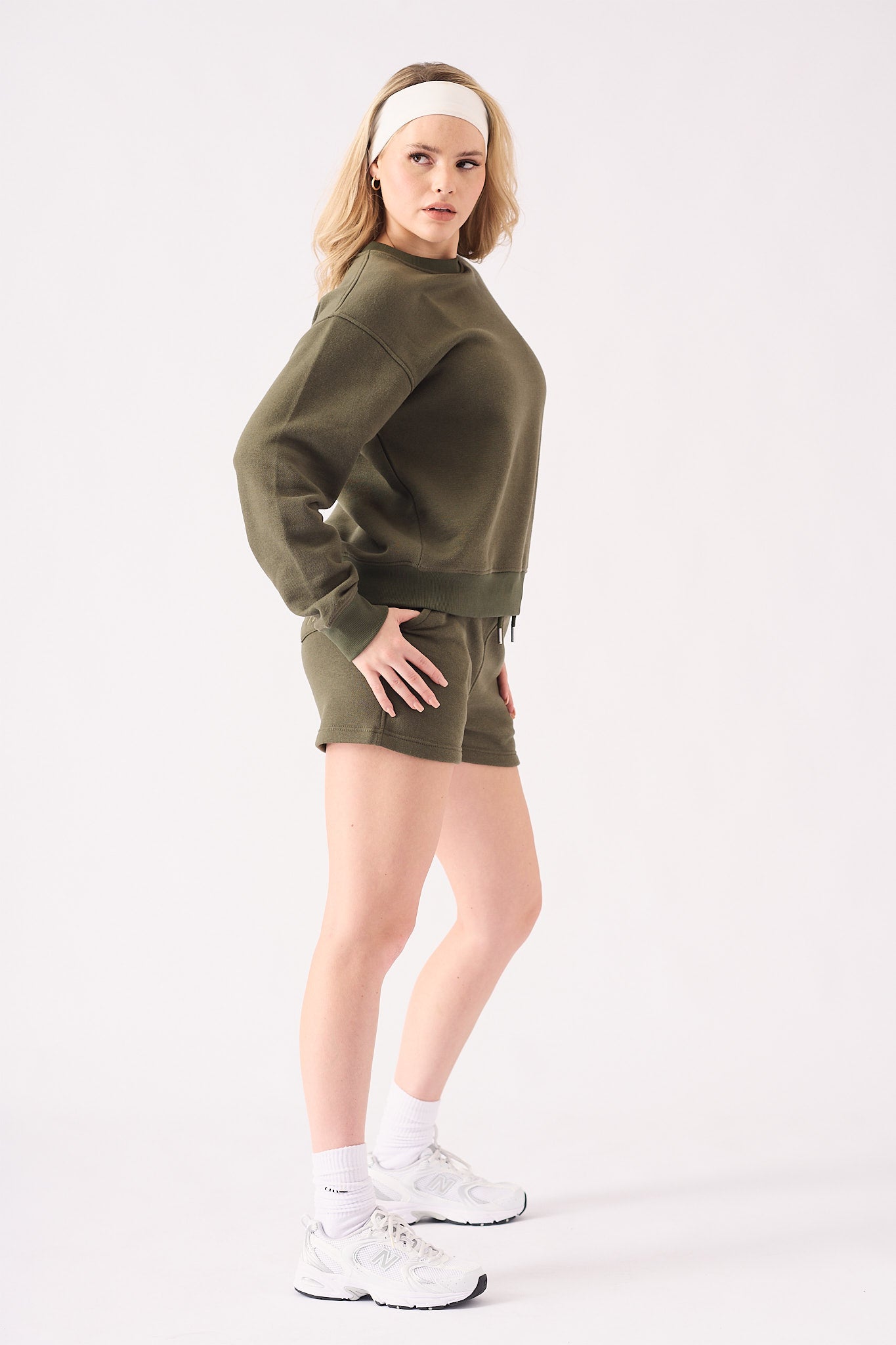 Side profile view of a woman wearing a comfortable khaki crew neck jumper