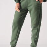 A woman wearing stylish khaki green joggers women in a front shot.