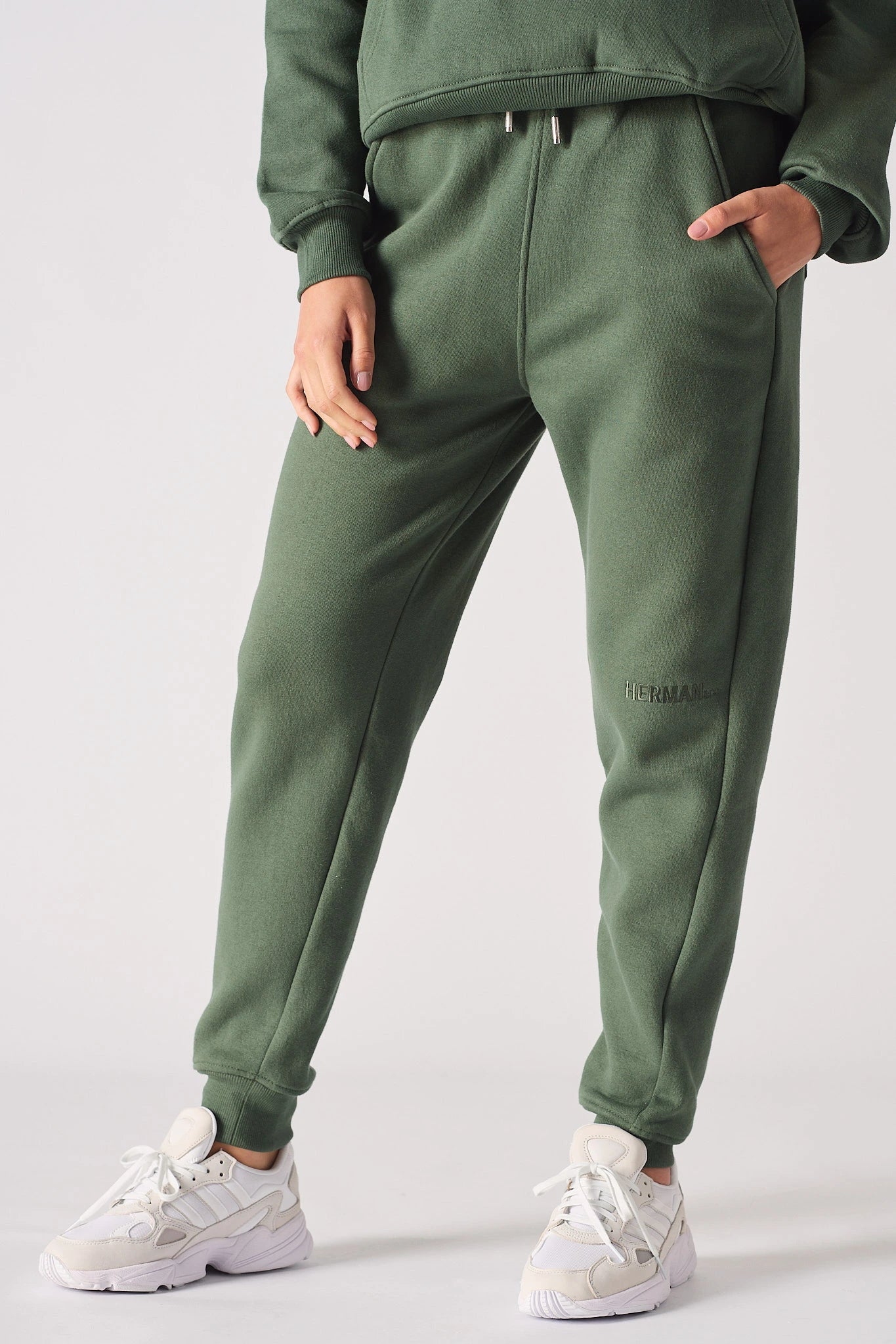 A woman wearing stylish khaki green joggers women in a front shot.