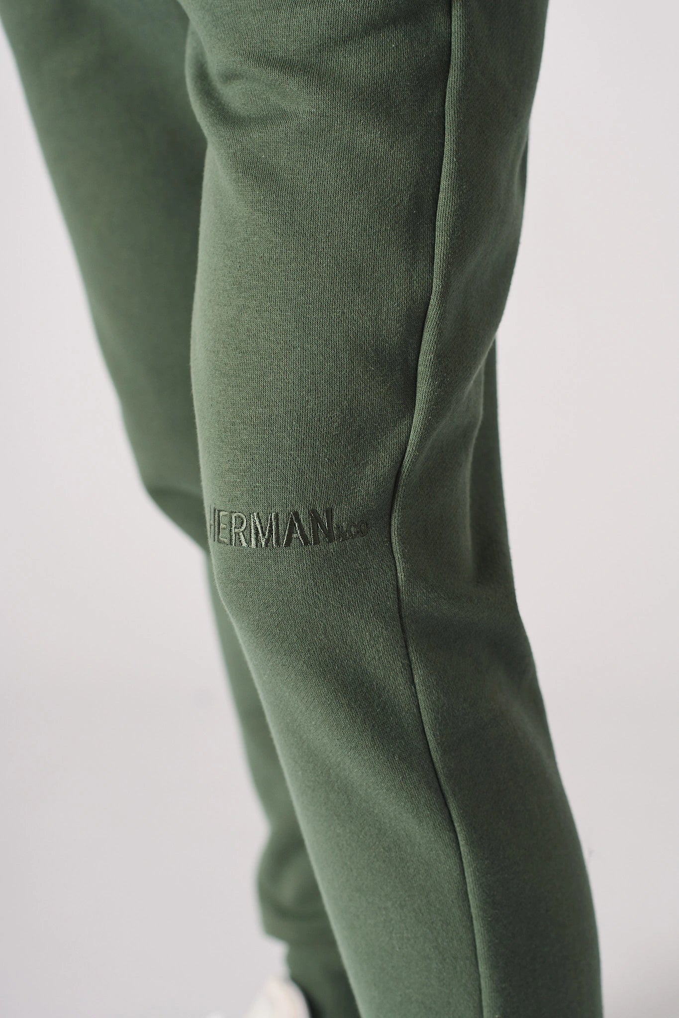 Detailed shot showing the tapered leg and cuff of khaki green joggers women.