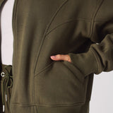 Close up view of the side pocket and soft fabric on a khaki sweatshirt