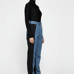 Model standing straight in ladies high-rise contrast panel jeans with a light blue front wash.