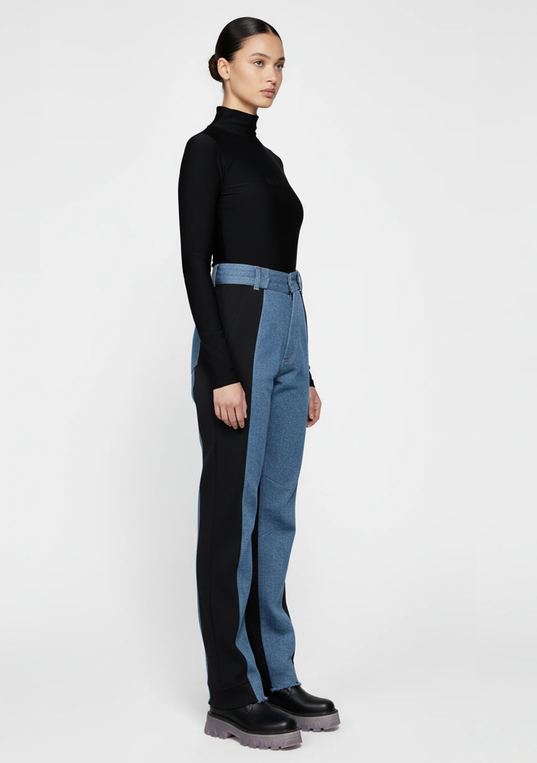 Model standing straight in ladies high-rise contrast panel jeans with a light blue front wash.