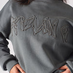 Close up showing the magnificent tonal 3D embroidery on the grey sweatshirt.