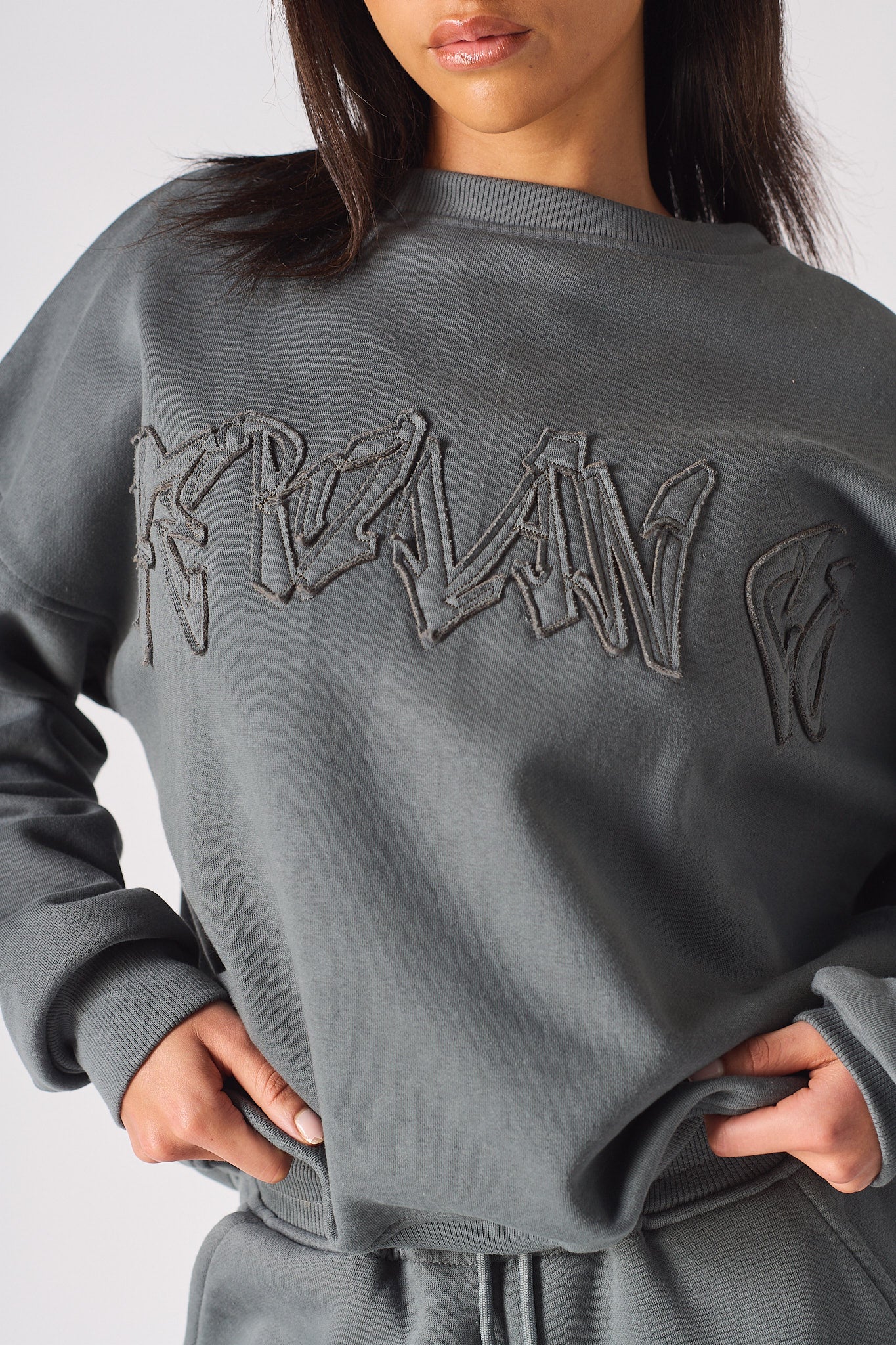 Close up showing the magnificent tonal 3D embroidery on the grey sweatshirt.