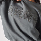 Detailed shot of the high quality fabric and embroidery on the ladies oversized grey sweatshirt.