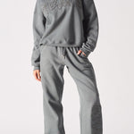 Full length front shot of a model wearing ladies oversized grey sweatshirt and matching joggers.