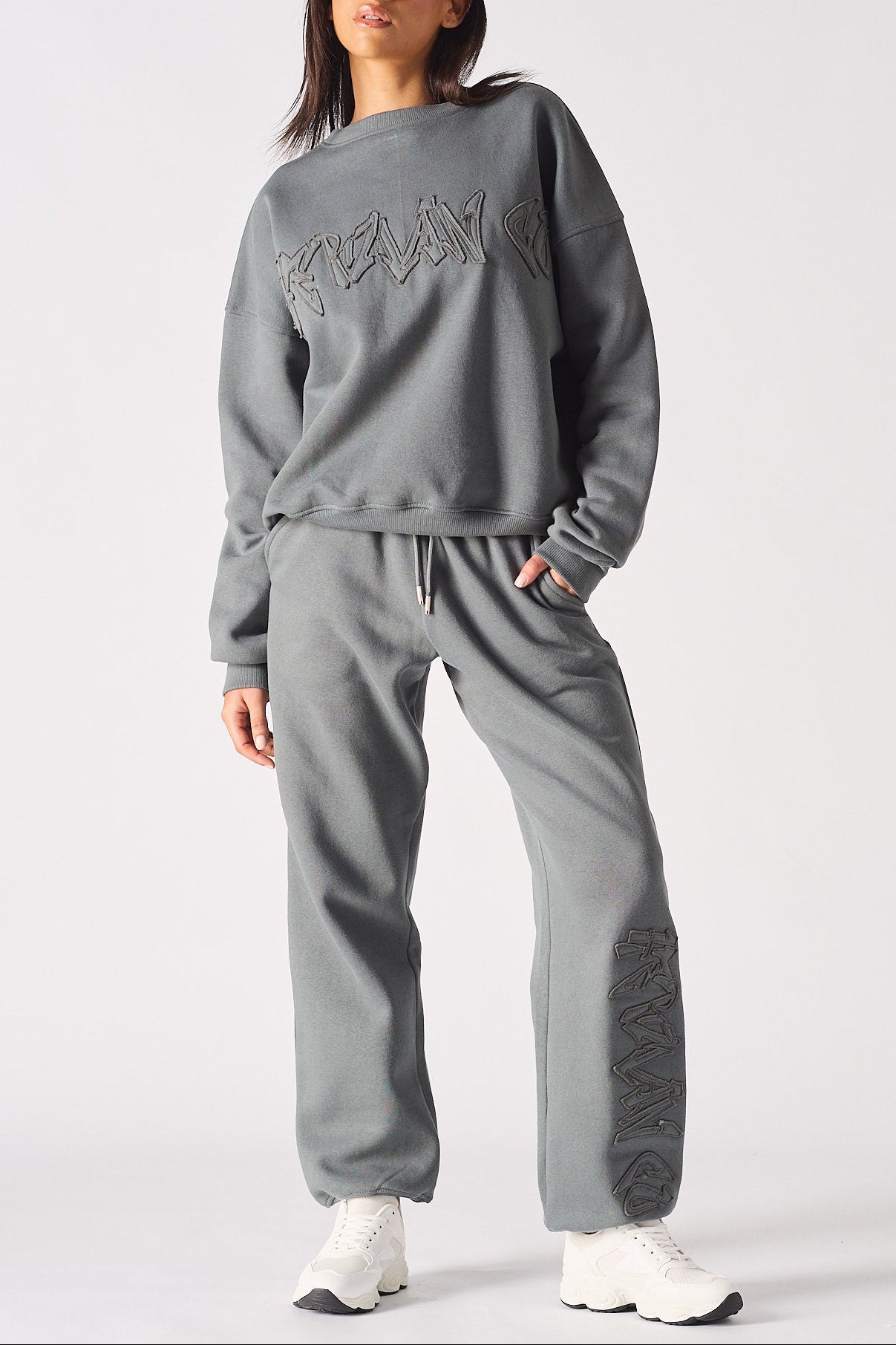 Full length front shot of a model wearing ladies oversized grey sweatshirt and matching joggers.