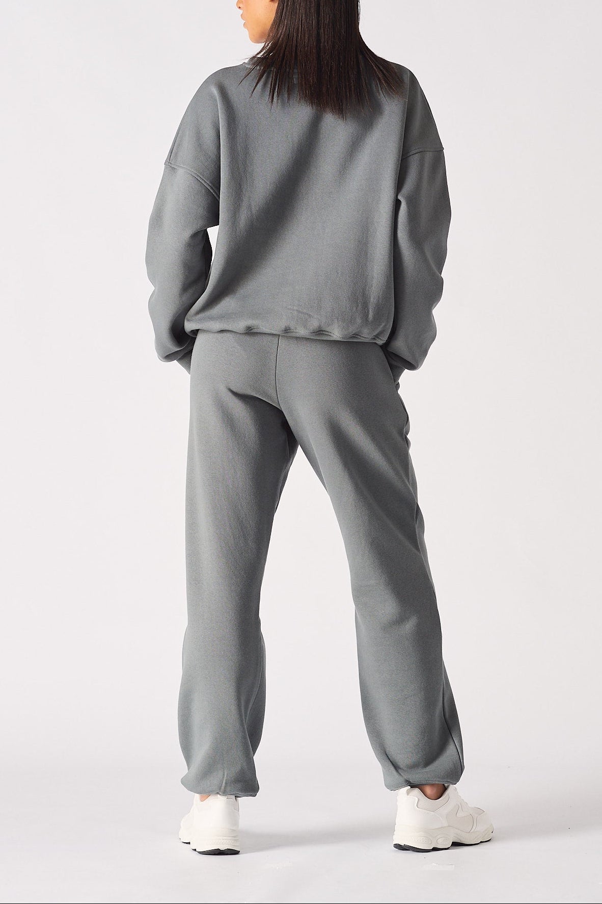 Back view of a model in the comfortable ladies oversized grey sweatshirt.